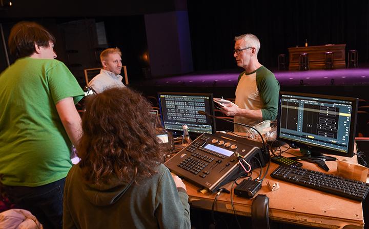 A BW professor works with students in the theatre